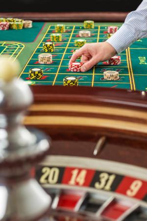 Giocatore piazza fiches sul tavolo della roulette in un casinò.